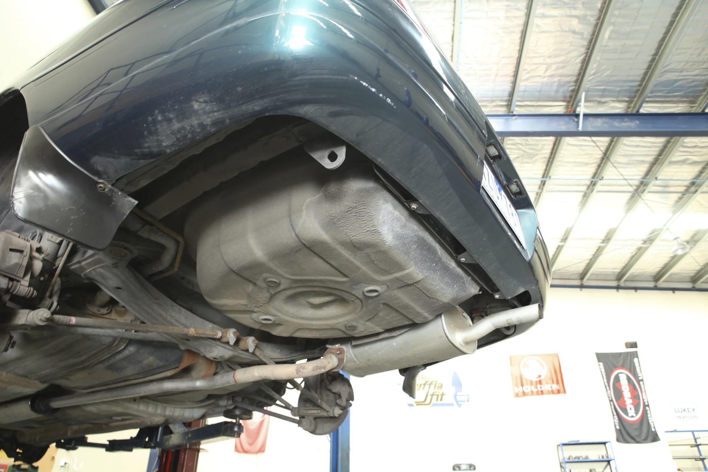 A vehicle underbody and exhaust on a workshop hoist