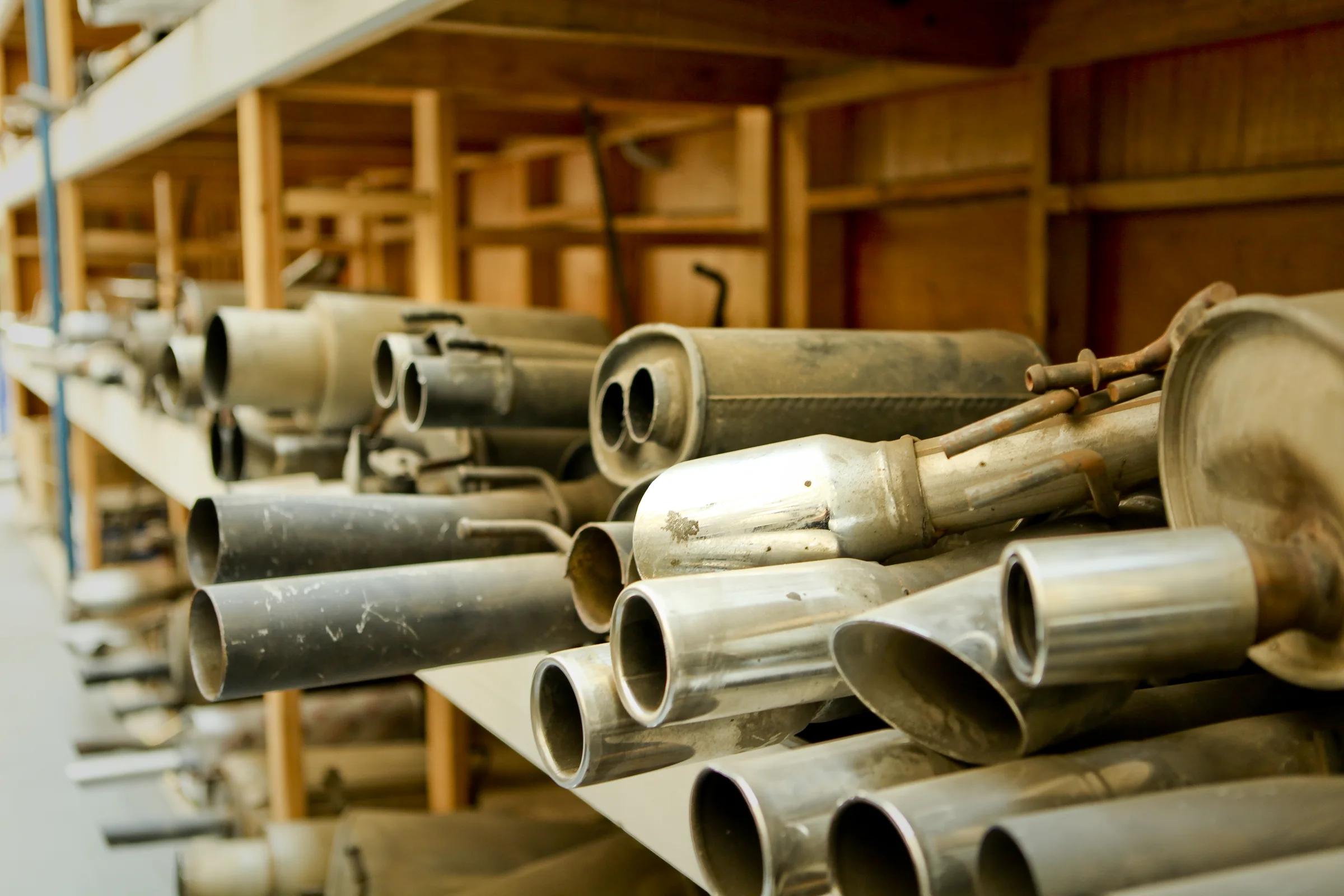 Exhaust and muffler components on the workshop shelves