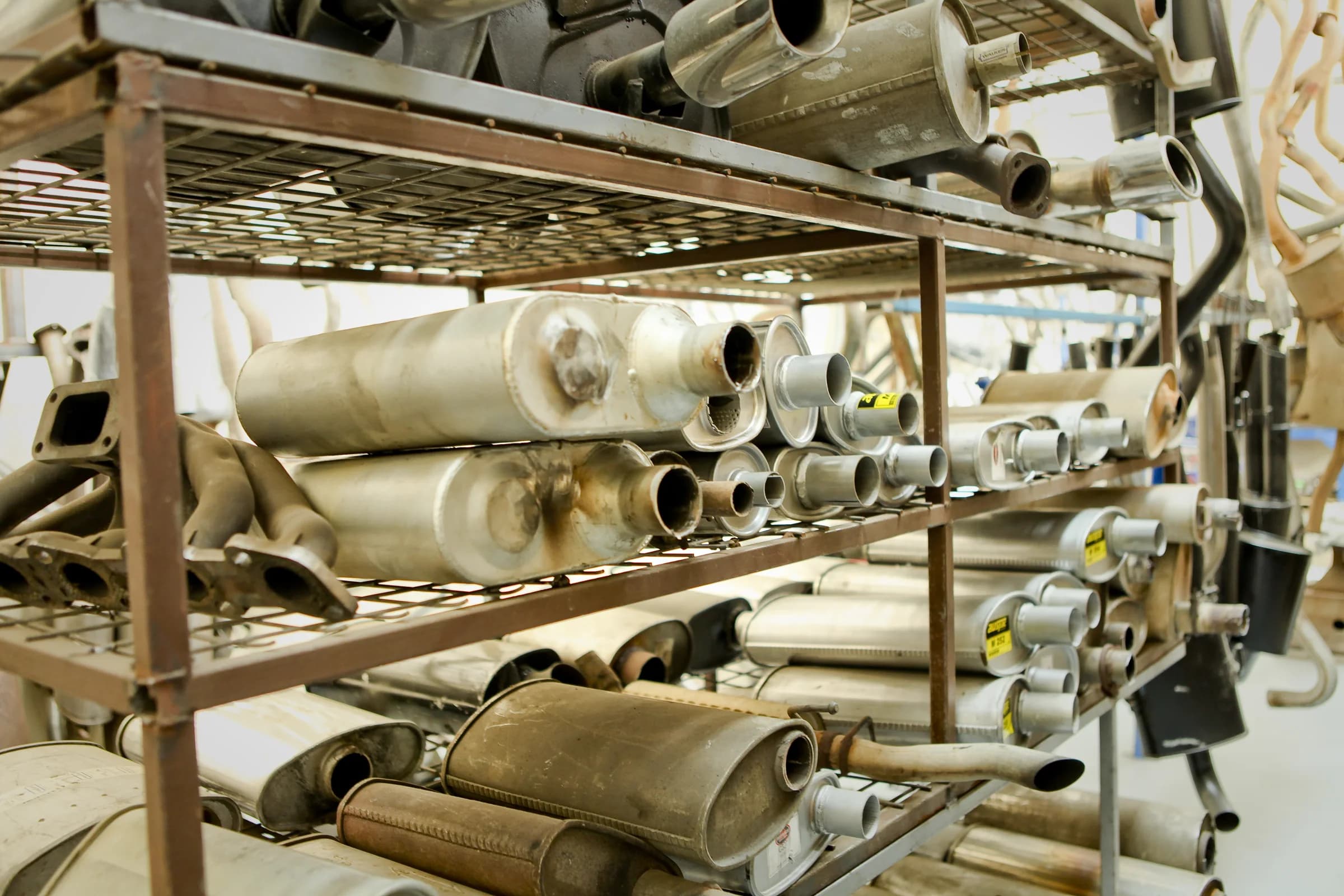 Mufflers and exhaust components stored in the workshop